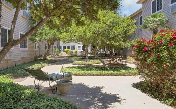 Shade trees and walking paths in the Lyndale San Angelo Senior Living community courtyard