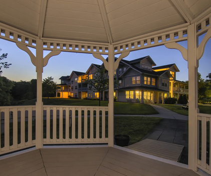View of White Oaks building from inside the outdoor gazebo at dusk