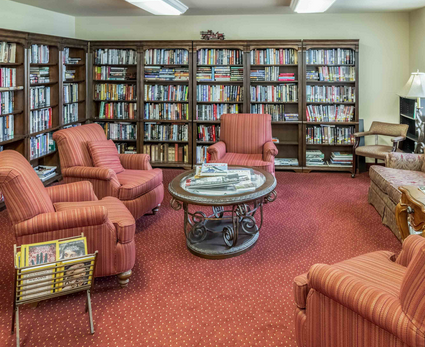 Resident library lined with bookshelves in White Oaks
