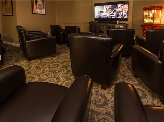 Creekside Oaks community movie theater with stuffed brown leather chairs
