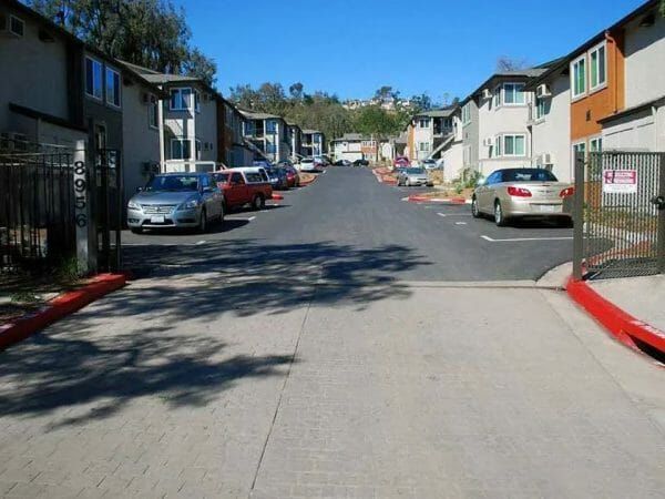 Street view with cars parked on both sides in front of buildings at Peppertree Senior Apartments