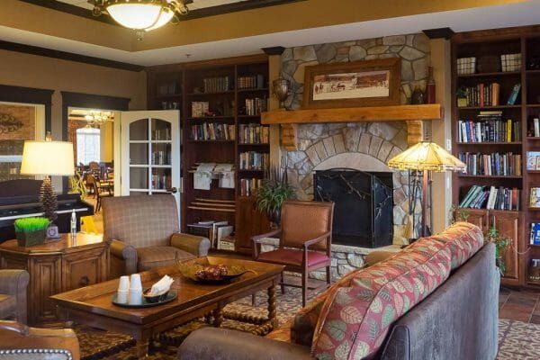 Community lobby and living area with a stone fireplace and resident seating in The Bridge at Alamosa