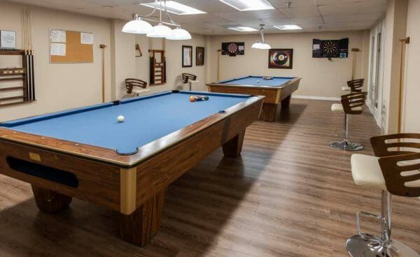 Blue felt covered pool tables in the Freedom Plaza Care Center billiards room