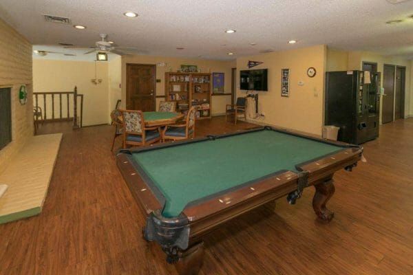 Green felt pool table and a poker table in the Canterbury Gardens game room