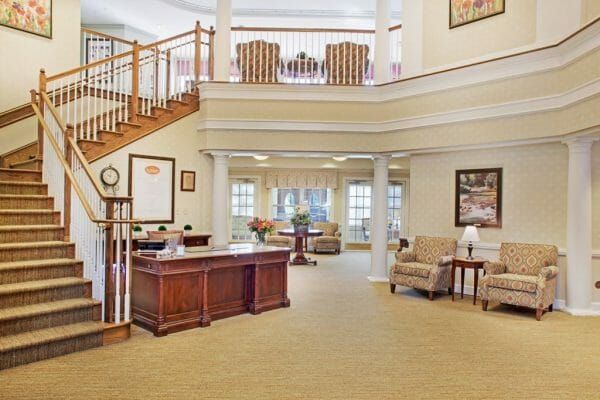 Two story Sunrise at Cherry Creek lobby with a grand staircase and reception desk