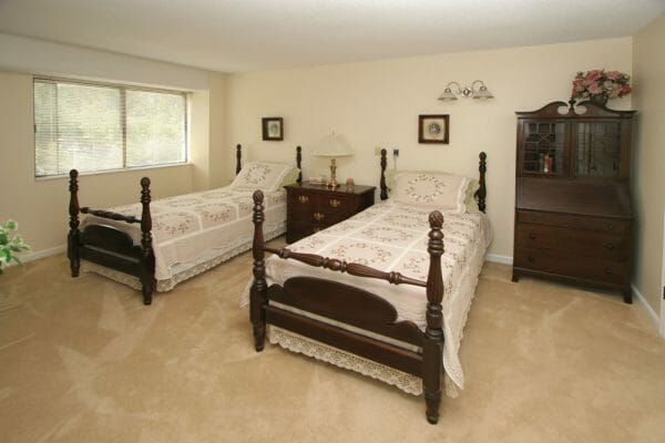 Twin beds in a model apartment at Elite Nursing & Rehab