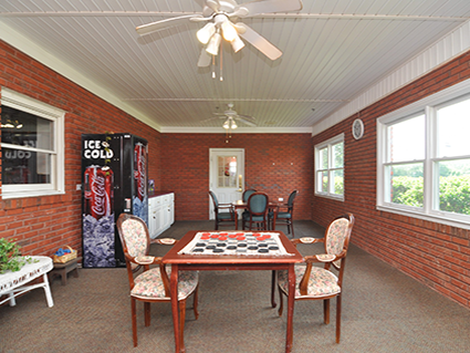 Activity room with tables and vending machines in Rose Wood Manor