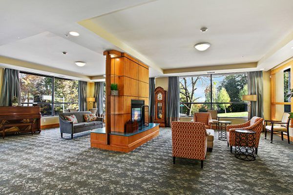 A two-sided fireplace and seating in Brookdale West Seattle's common area