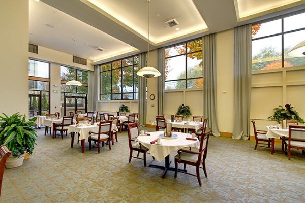 Brookdale West Seattle's community dining room, with high ceilings and large windows