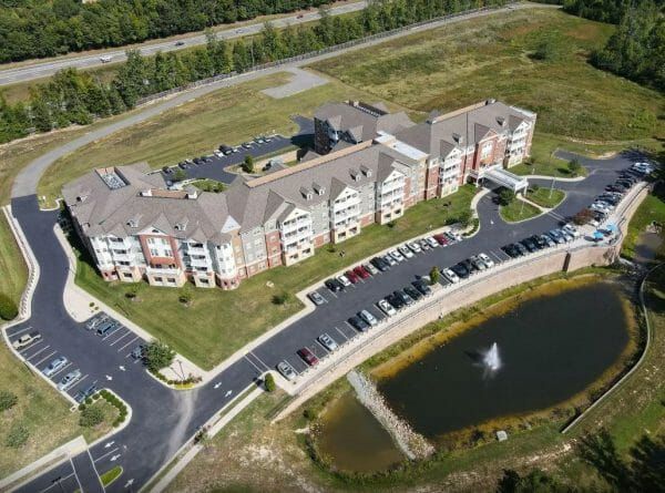 An aerial view of Discovery Village at the West End's independent living building, parking lot and pond