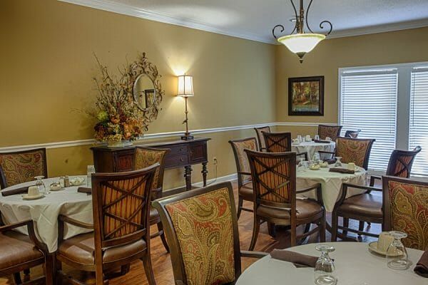 The Brennity at Fairhope community dining room with 4 top tables and chairs