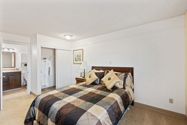 A model apartment bedroom at Farrington Court, with a view into the closet and bathroom