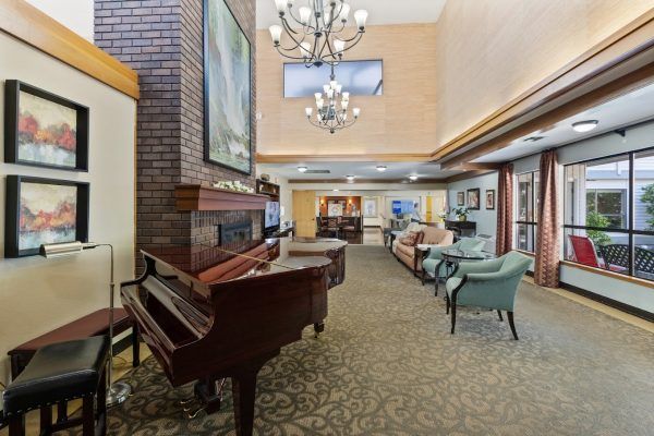 The two-story lobby at Farrington Court, with a grand piano and various seating in front of a tv
