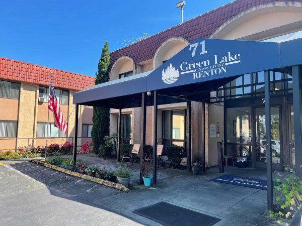 The front entrance to Greenlake Senior Living Renton, covered by a wide blue awning