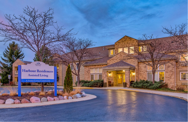 The exterior and front entrance to the Assisted Living building at Harbour Village at dusk