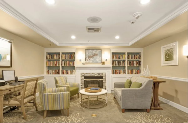 Bookshelves, a fireplace, comfortable seating and a computer station in the library at Island House