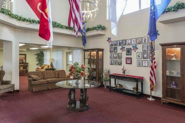 Lobby area with hanging flags, coffee table, couch, frames on the wall at Shasta Estates
