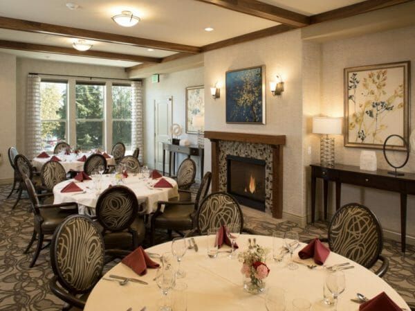 Tables in front of the fireplace in the Oakmont of San Jose dining room