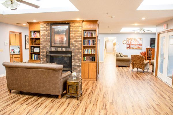 The fireside lounge at Our House Senior Living - Wausau Assisted Care, and the community living room beyond