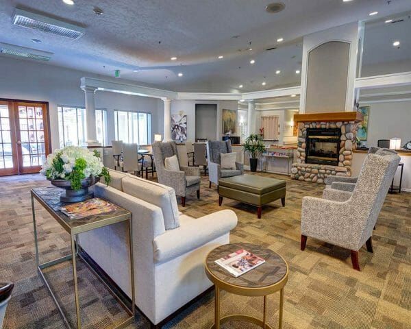 Sofas and stuffed chairs around a fireplace in the Paramount Court Senior Living living room