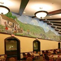 The dining hall at Pennybyrn at Maryfield with dark wood exposed beams and murals on the walls