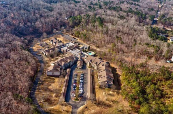 A closer aerial view of Regency Pointe's buildings, parking lot and the surrounding, wooded area