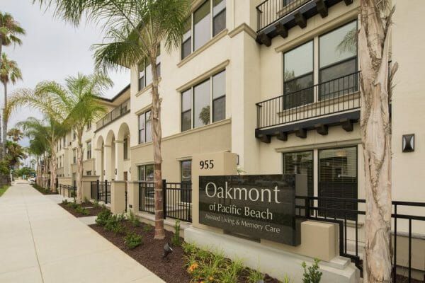 Main building with street sign on the fence at Oakmont of Pacific Beach