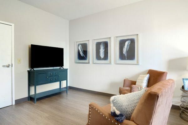 Two armchairs in front of a tv in the model studio apartment at Rittenhouse Village At Northside