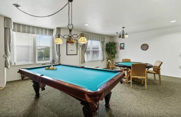 Seaton Voorhees' game room, with a pool table with green felt, a poker table, and a dart board
