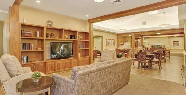 Comfortable seating in front of a tv in the Seven Lakes Memory Care community living room