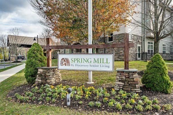 Spring Mill's community sign, with the building in the background