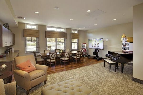 Grand piano and long dining table in the Sunol Creek Memory Care common area