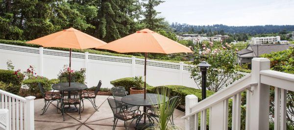 Sunrise of Mercer Island's patio, with a view of the trees and city skyline in the distance
