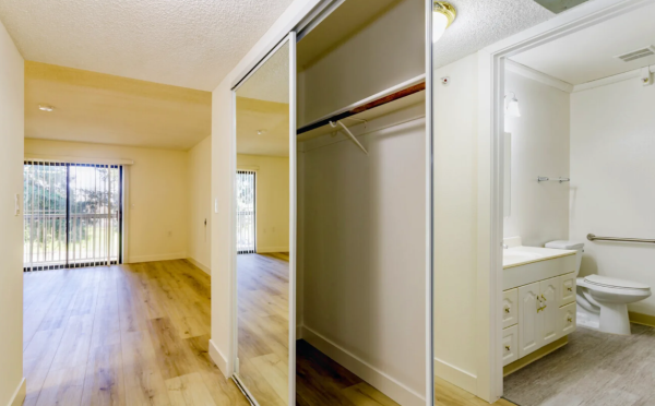 A vacant apartment at The Atrium at Carmichael, with a view into the bathroom, a closet and the living area