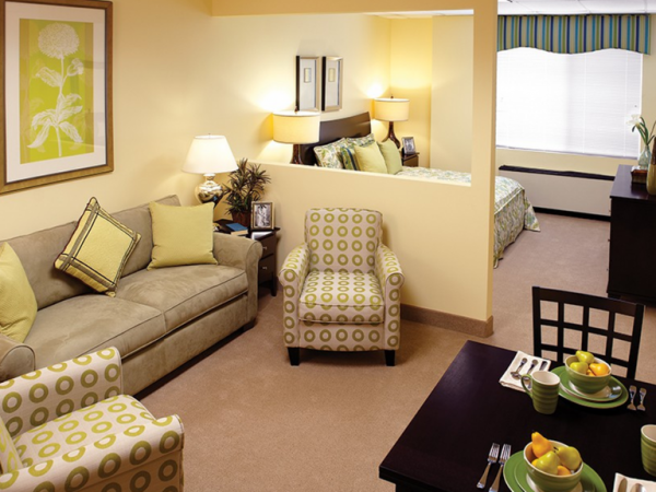 The Bristal Assisted Living at Lynbrook resident apartment interior with living area and bedroom separated by halfwall