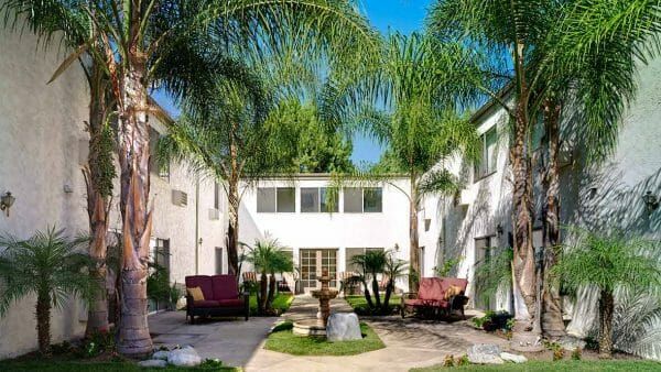 Resident courtyard with seating under palm trees at Atria Covina