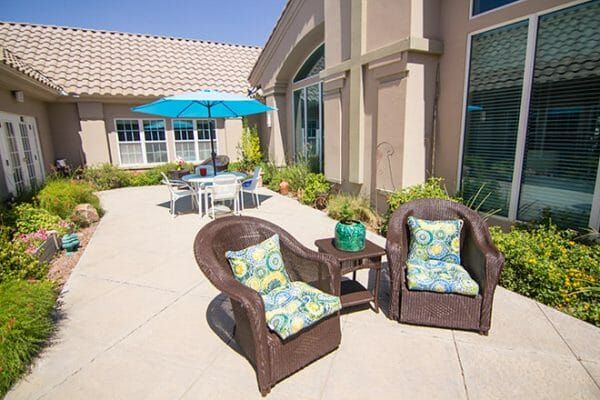 Wicker chairs and an umbrella table on the Brookdale Tanque Verde patio