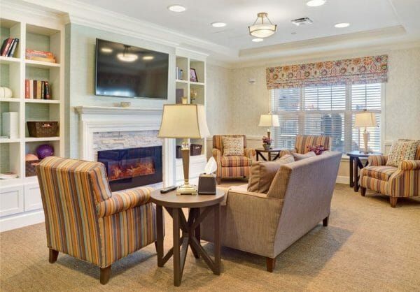 Comfortable seating options in front of a fireplace and tv in the Sunrise at Cherry Creek Reminiscence living room