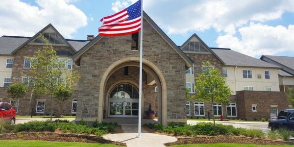 Brick faced covered entrance and American flag at Cahaba Ridge Retirement Community