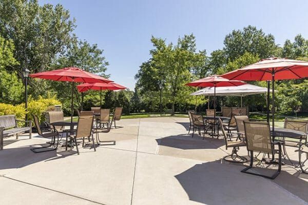 Red umbrella tables on the Brookdale Meridian Westland patio