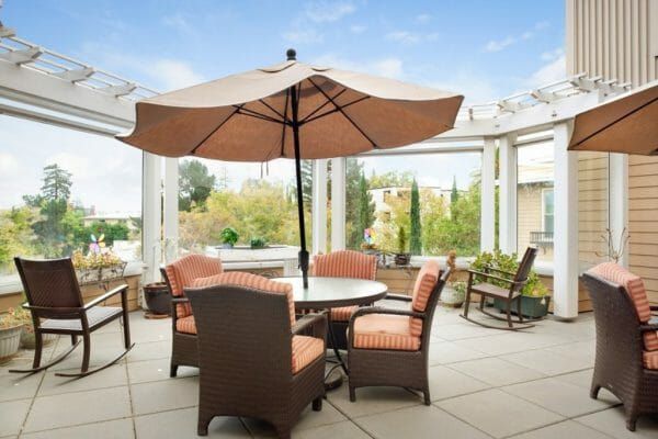 Outdoor patio with umbrella tables at Sunrise of Palo Alto