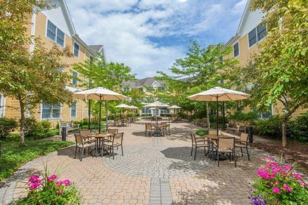 Umbrella covered dining tables in the River Ridge at Avon outdoor courtyard
