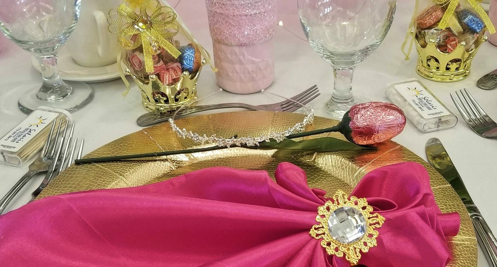 Table setting with pink napkin over gold plate