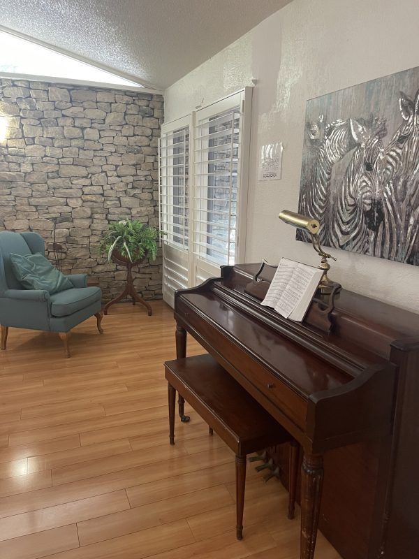 KinCare Assisted Living entertainment room for residents with piano