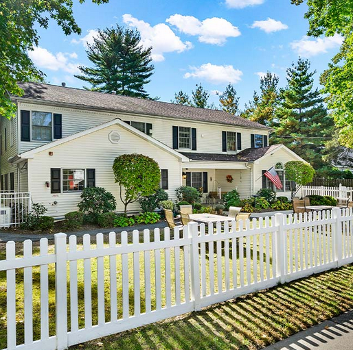 White picket fence in front of Fox Trail Memory Care Living at Cresskill
