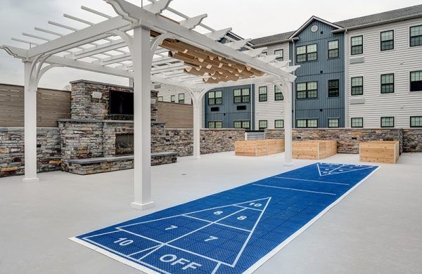 The outdoor fireplace and shuffleboard court at Crescent Fields at Huntingdon Valley