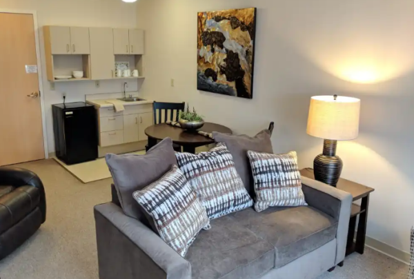 The modern living, dining and kitchenette areas of a model apartment at O’Neill Healthcare Bay Village