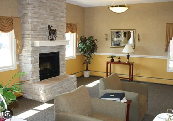 Two armchairs and a fireplace in O’Neill Healthcare North Ridgeville's lobby