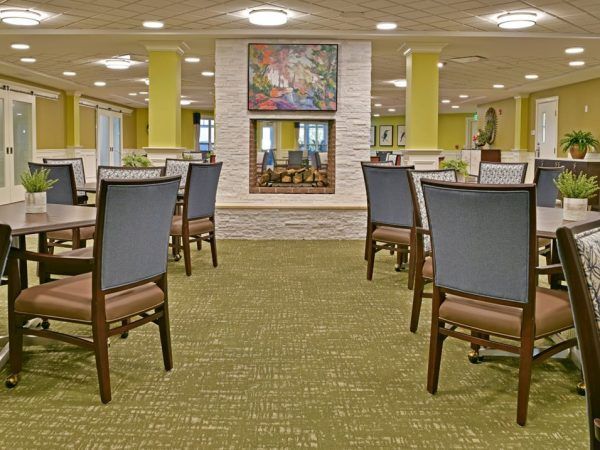 Rose Senior Living Beachwood's community dining room, with a double-sided fireplace