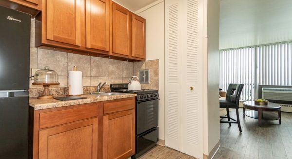 The kitchenette in a model studio apartment at Skyline Tower Senior Apartments, which is separated from the living room by a pantry with a bi-fold door
